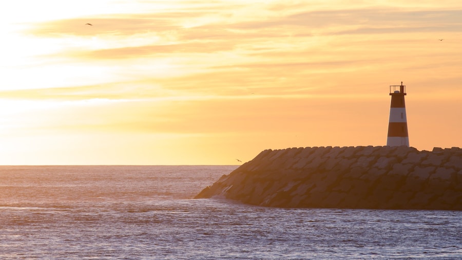 Barra Beach which includes a lighthouse, a sunset and general coastal views