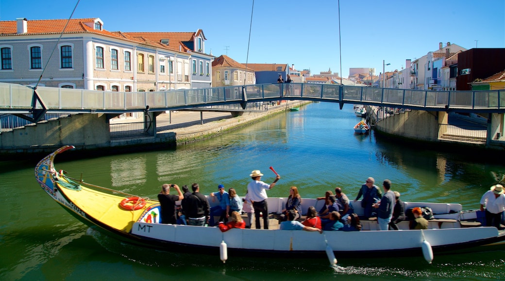 Aveiro que incluye embarcaciones y un río o arroyo y también un grupo pequeño de personas