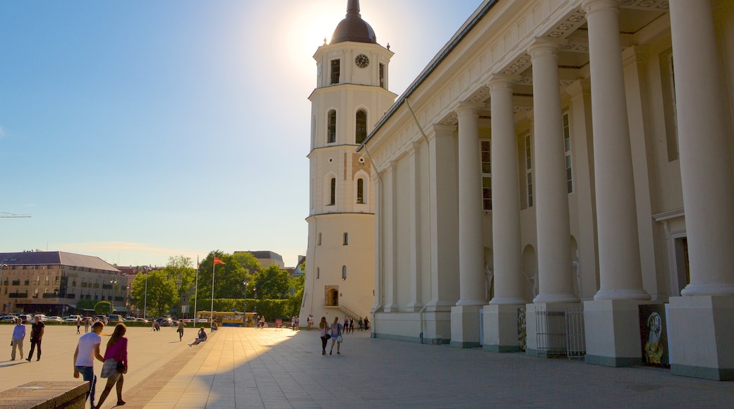Catedral de Vilnius que incluye elementos del patrimonio y un parque o plaza y también un pequeño grupo de personas