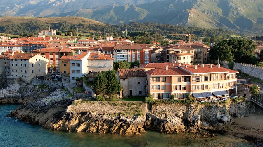Llanes which includes rocky coastline, tranquil scenes and a coastal town