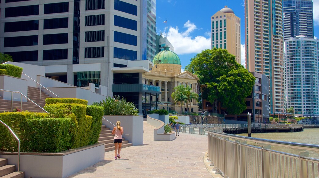 Eagle Street Pier featuring a city and a high rise building as well as an individual femail