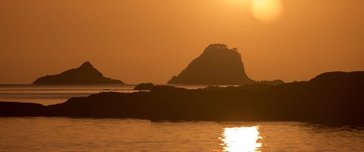 Cathedral Cove Beach featuring general coastal views, rocky coastline and a sunset