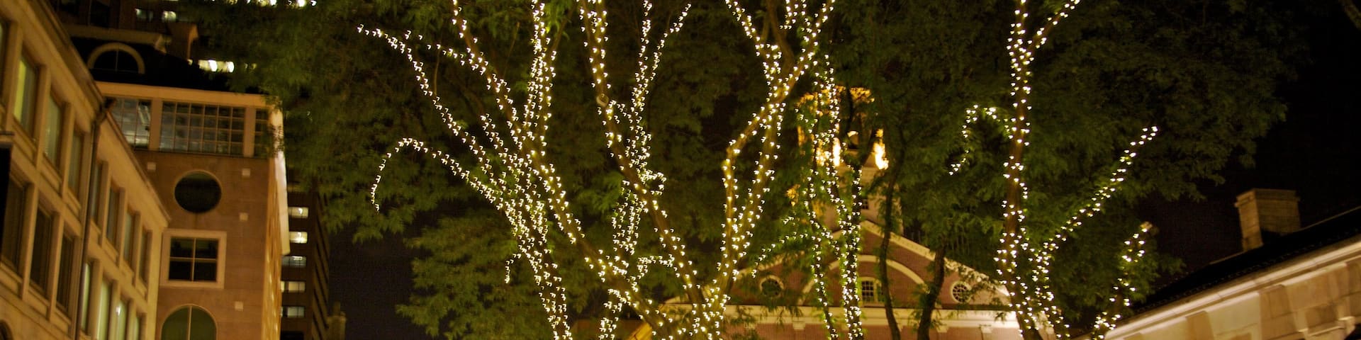 Downtown Boston showing a city and night scenes as well as a small group of people