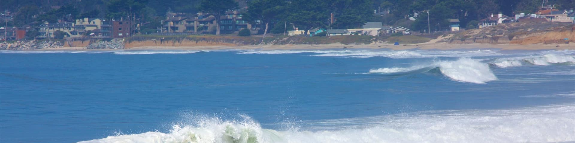 Half Moon Bay showing a beach and general coastal views as well as a small group of people