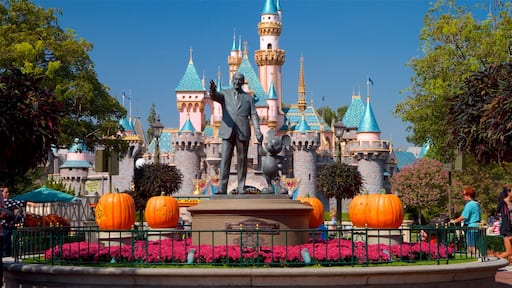 Disneyland® Park showing rides, a statue or sculpture and flowers