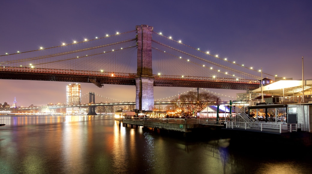 Puente de Brooklyn ofreciendo un puente, una ciudad y escenas nocturnas