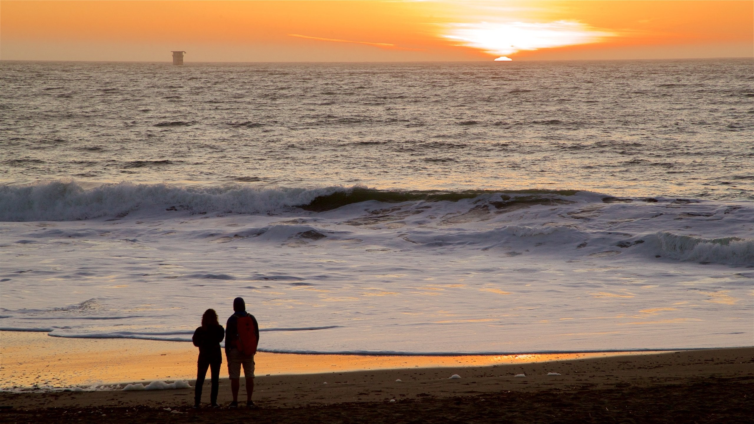 Baker Beach showing surf, a sunset and general coastal views