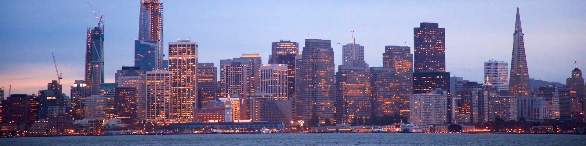 Treasure Island montrant gratte-ciel, rivière ou ruisseau et coucher de soleil