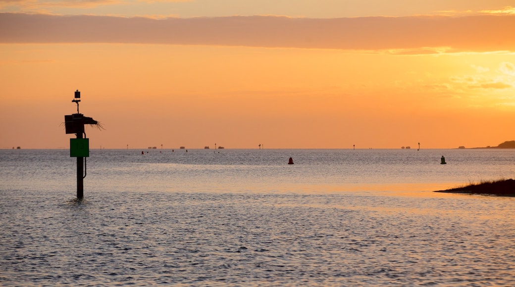 Oregon Inlet Fishing Center som viser en solnedgang og en bugt eller havn