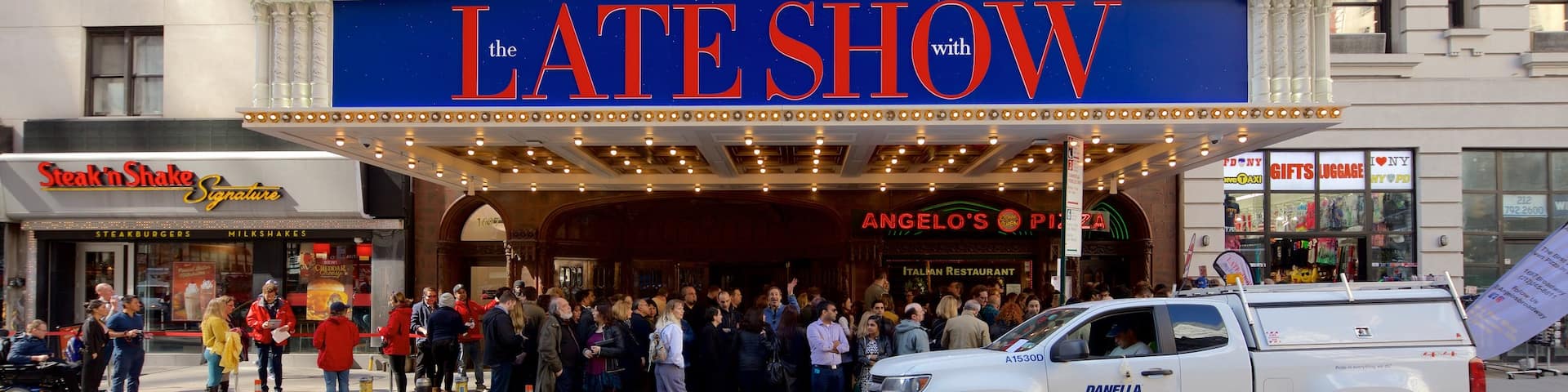 Ed Sullivan Theater showing a city and signage as well as a large group of people
