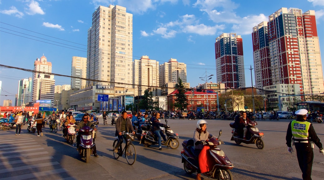 Kunming bevat een zonsondergang, een stad en fietsen