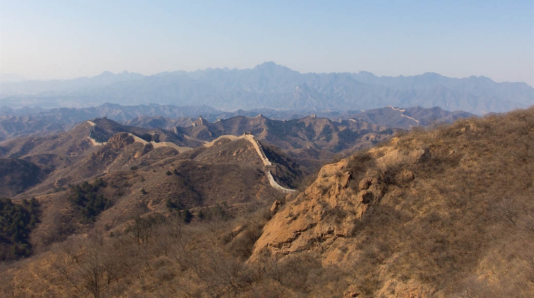 Jinshanling Great Wall som inkluderar landskap, en solnedgång och stillsam natur