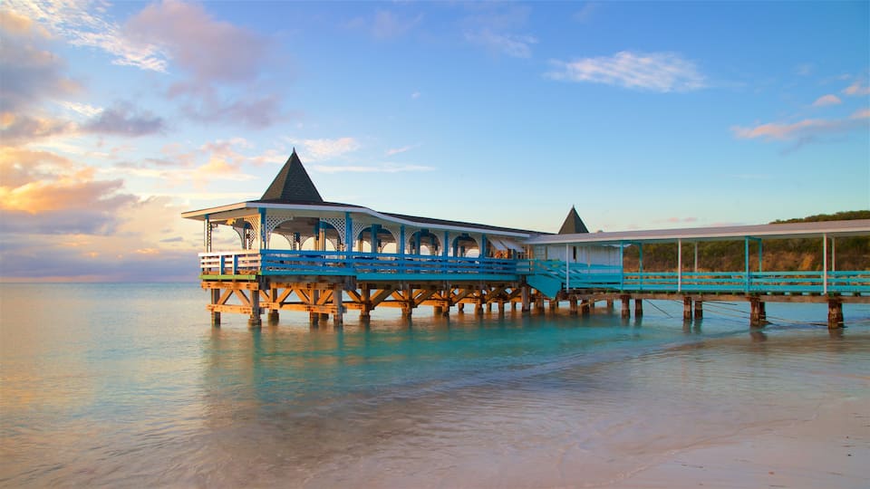 Dickenson Bay Beach featuring a sandy beach, a sunset and general coastal views
