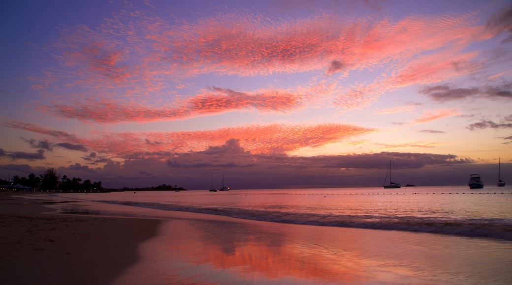 Dickenson Bay Beach som inkluderer sandstrand, solnedgang og kyst