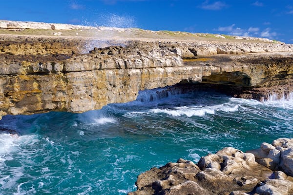 Devil\'s Bridge which includes rocky coastline, waves and general coastal views
