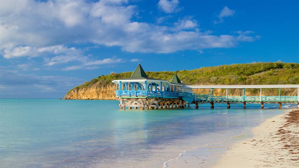 Dickenson Bay Beach which includes rugged coastline, general coastal views and a sandy beach