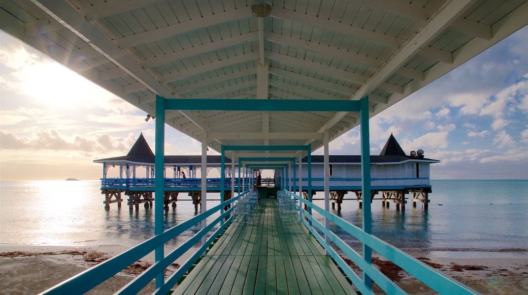 Dickenson Bay Beach which includes general coastal views, a sandy beach and a sunset