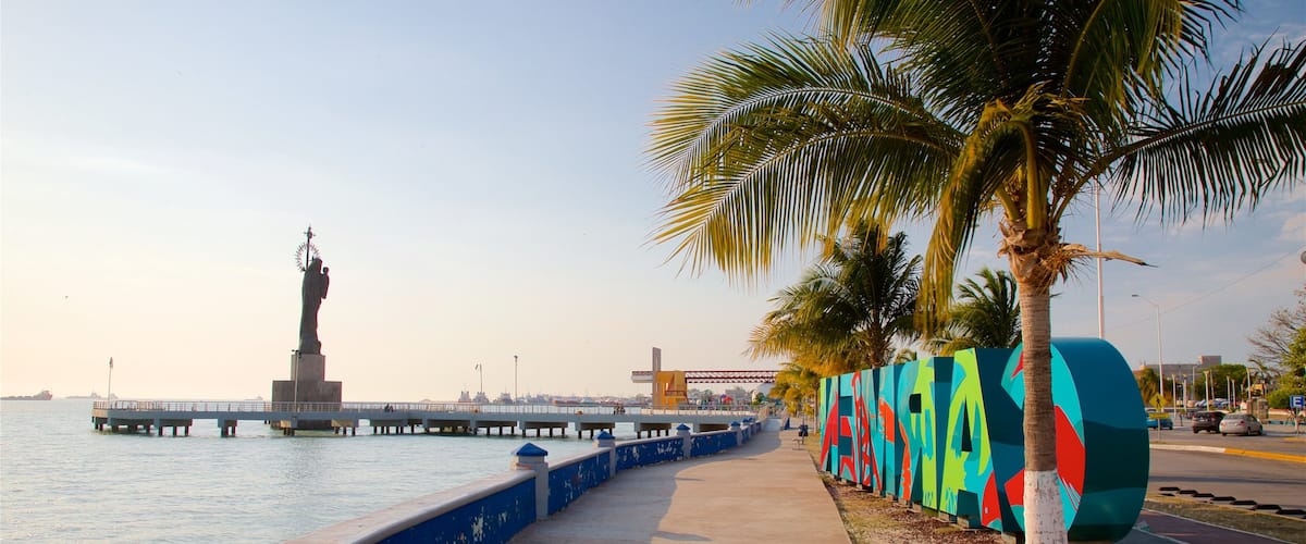 Ciudad del Carmen which includes signage, a sunset and a statue or sculpture