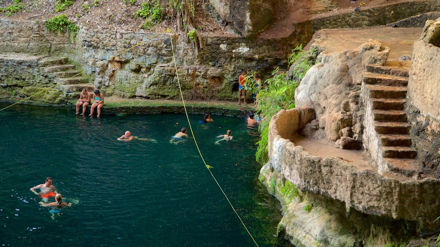 Cenote Zaci ofreciendo natación y un lago o laguna y también un grupo pequeño de personas