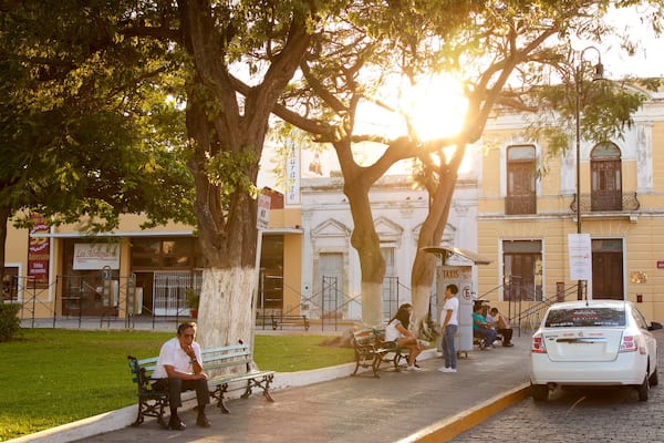 Parque de La Mejorada featuring a sunset and a garden as well as a small group of people