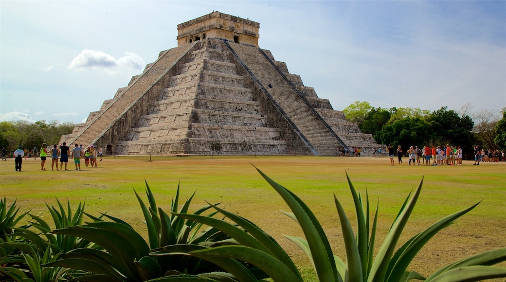 Pyramid of Kukulkan showing a park and heritage architecture as well as a small group of people