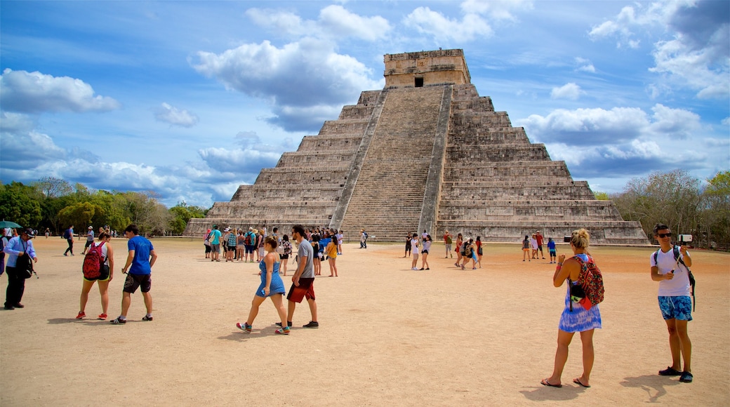 Piramide di Kukulkan che include architettura d\'epoca cosi come un piccolo gruppo di persone