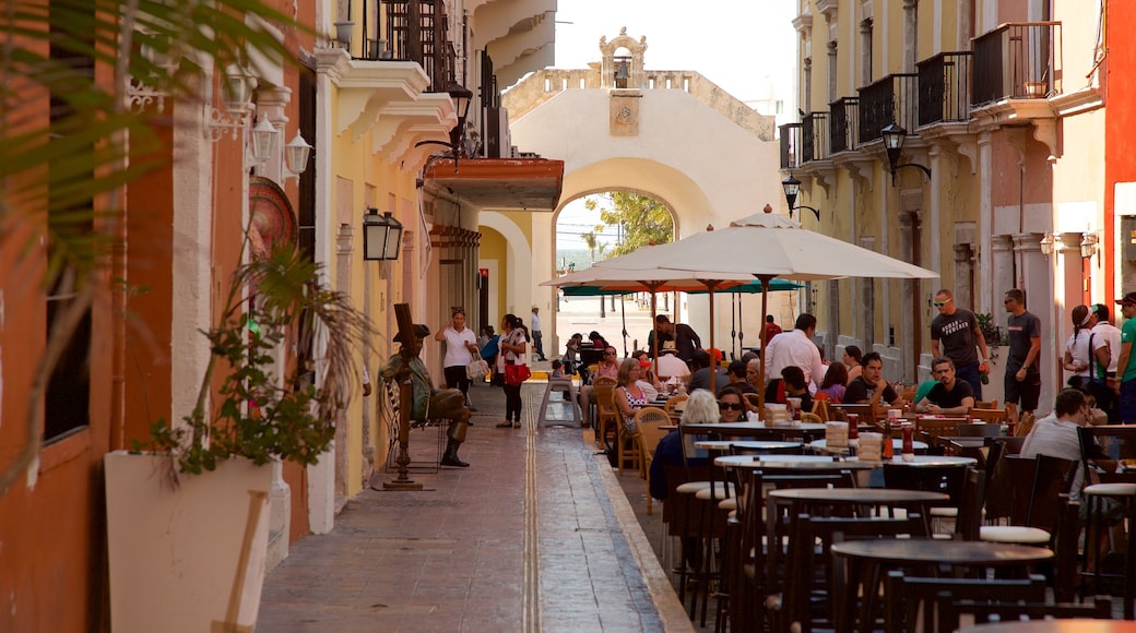 Monumento Puerta del mar mostrando comer al aire libre y también un pequeño grupo de personas