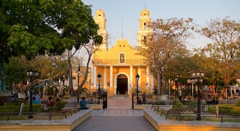 Our Lady of Carmen Church which includes a church or cathedral, a park and a sunset