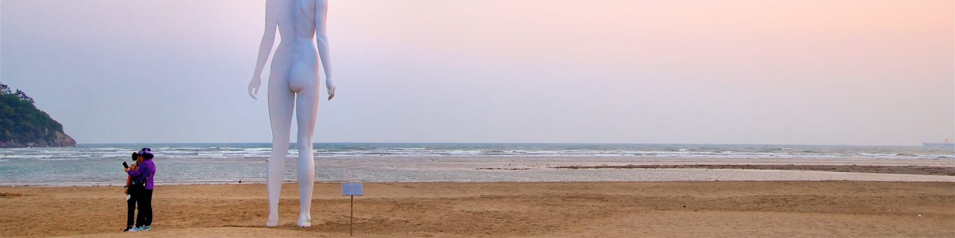 Playa de Dadaepo ofreciendo una puesta de sol, vistas generales de la costa y arte al aire libre