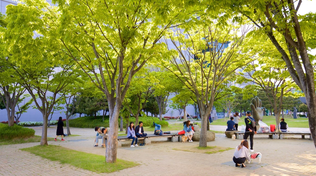 Museo de Arte Moderno de Busan que incluye un jardín y también un pequeño grupo de personas