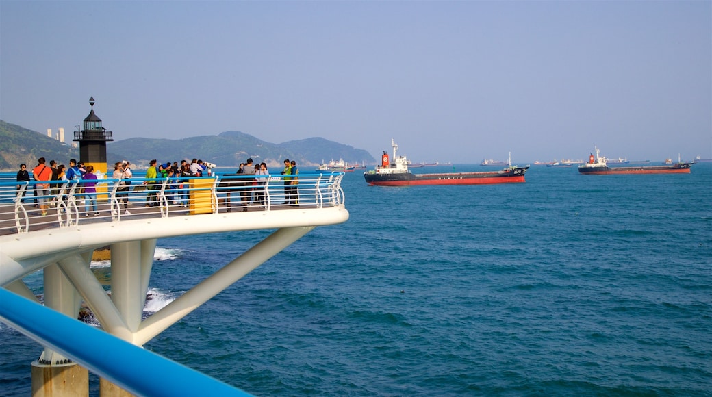 Songdo Beach which includes general coastal views and a bay or harbour as well as a small group of people