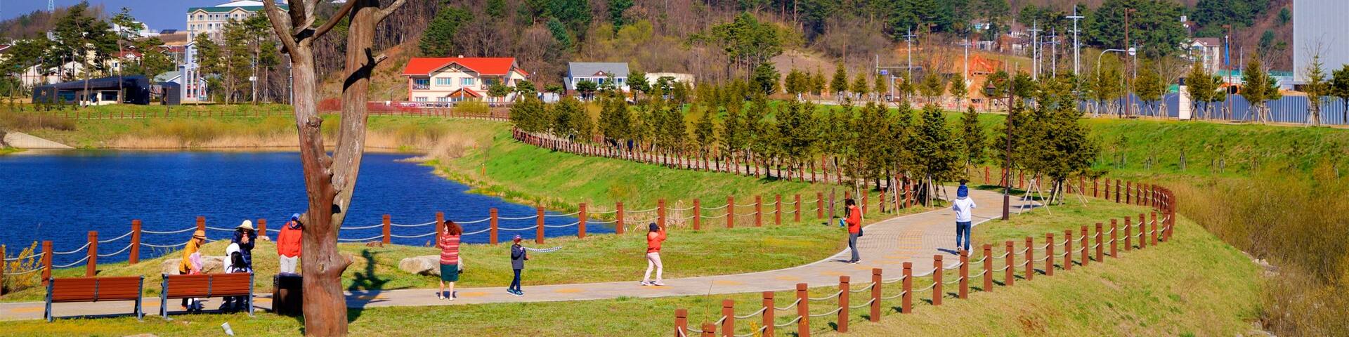 Alpensia Ski Resort featuring a lake or waterhole and a garden as well as a small group of people