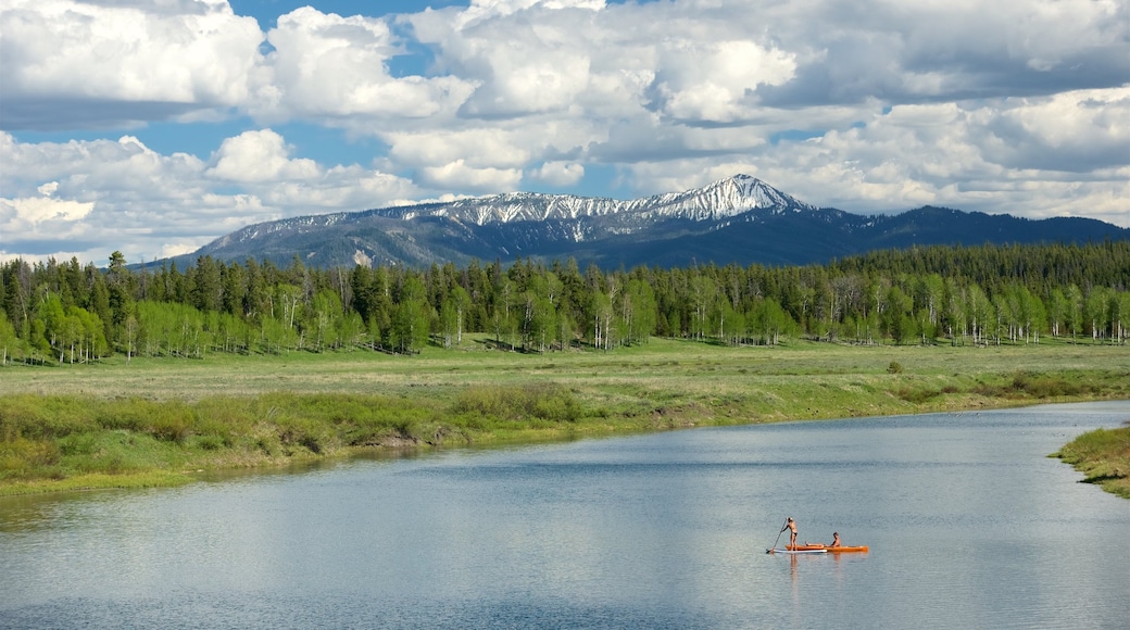 Oxbow Bend featuring kayaking or canoeing, tranquil scenes and mountains