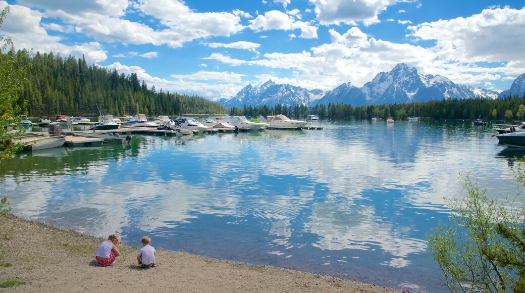 Colter Bay Visitor Center featuring a lake or waterhole and a bay or harbour as well as children