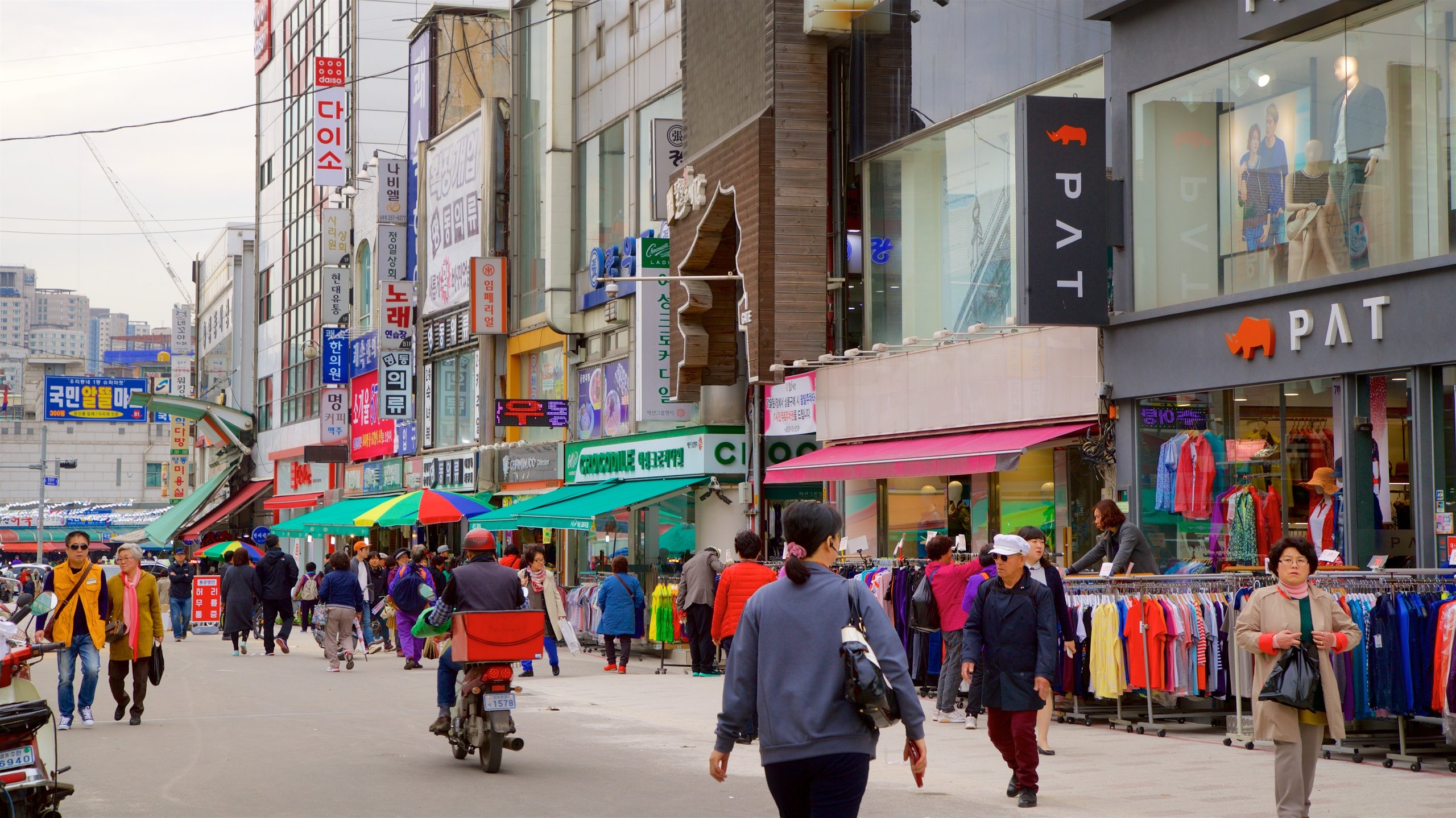 Suwon showing shopping and a city as well as a small group of people