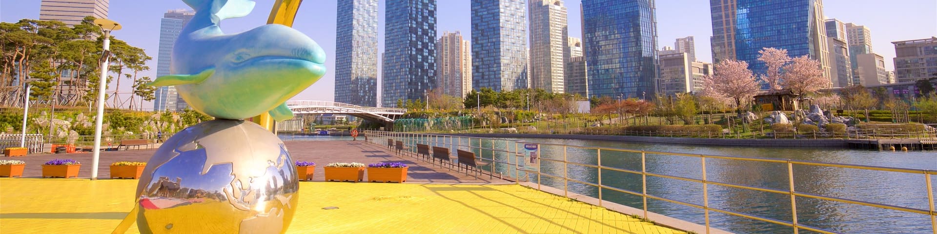 Songdo Central Park showing outdoor art, a river or creek and a skyscraper