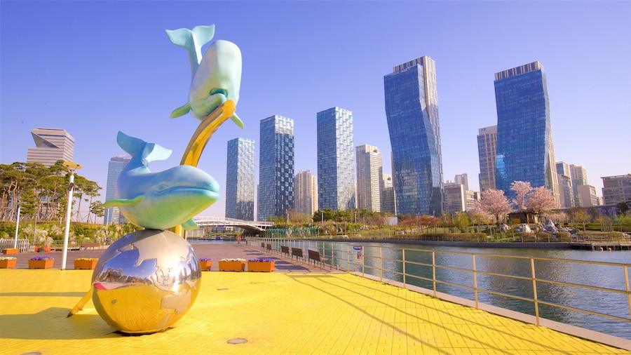 Songdo Central Park showing outdoor art, a river or creek and a skyscraper