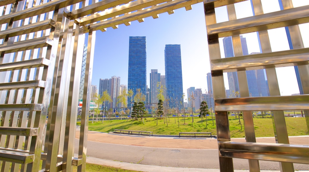 Songdo Central Park which includes a garden, a skyscraper and a sunset