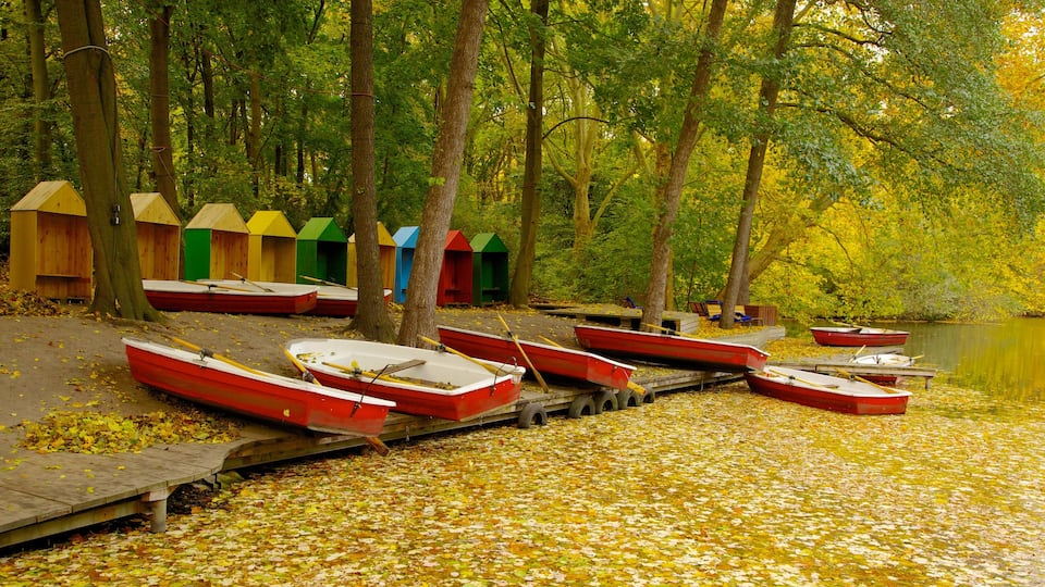 Colorful boat sheds and red boats along the tranquil waters of Tiergarten in Berlin during autumn