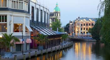 Amsterdam som omfatter gadeliv, en flod eller et vandløb og en by
