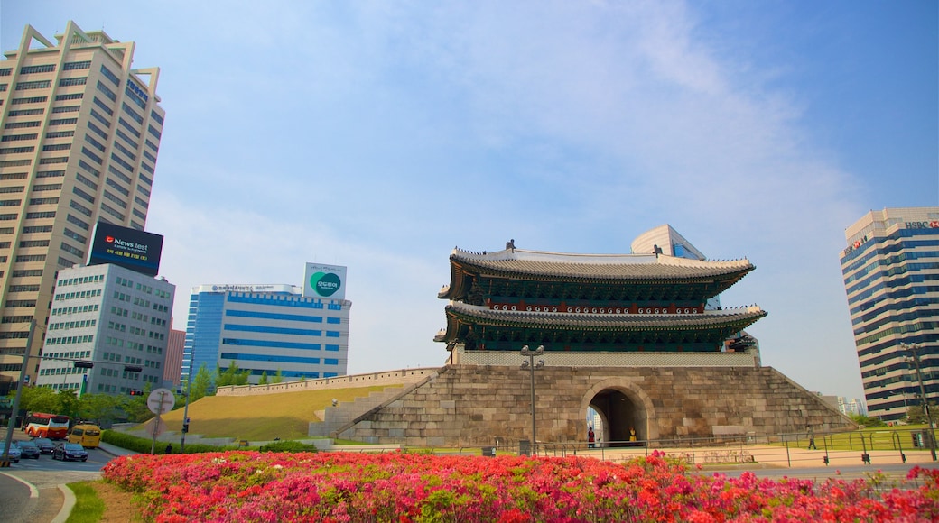 Sungnyemun Gate which includes wildflowers, a city and heritage architecture