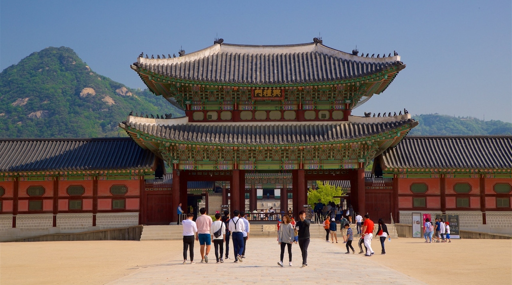 Palacio Gyeongbok ofreciendo patrimonio de arquitectura y un parque o plaza y también un pequeño grupo de personas