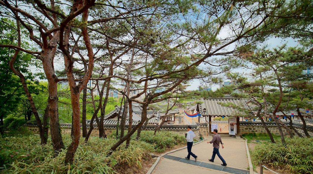 Namsangol Hanok Village showing a garden as well as a couple