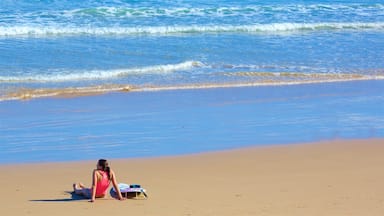 Great Ocean Road featuring general coastal views and a sandy beach as well as an individual female