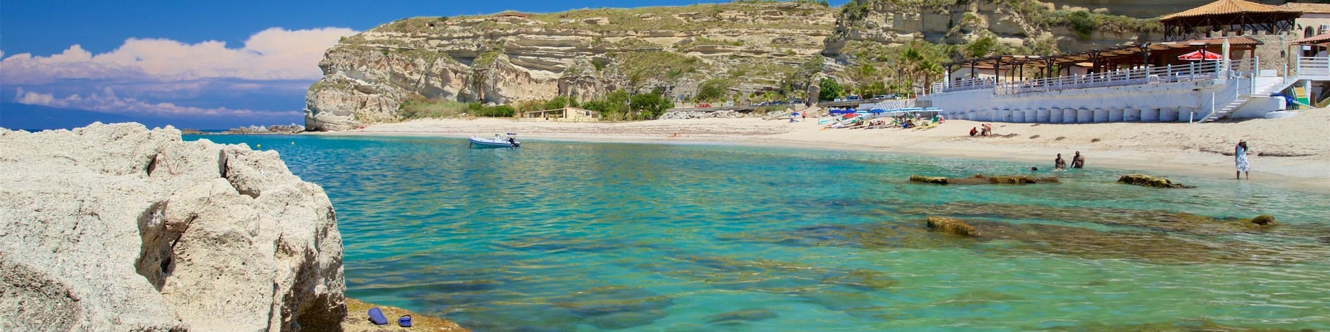 Riaci Beach which includes rocky coastline, general coastal views and tropical scenes