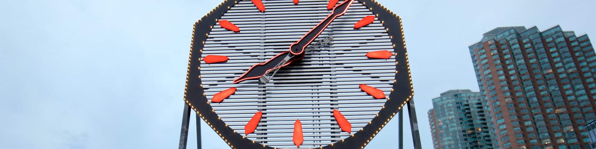 Reloj Colgate ofreciendo una ciudad y señalización y también un pequeño grupo de personas