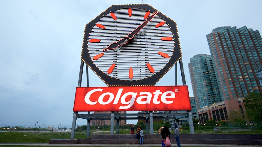 Colgate Clock mostrando segnaletica e città cosi come un piccolo gruppo di persone