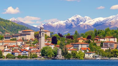 Verbania which includes mountains, a small town or village and a lake or waterhole