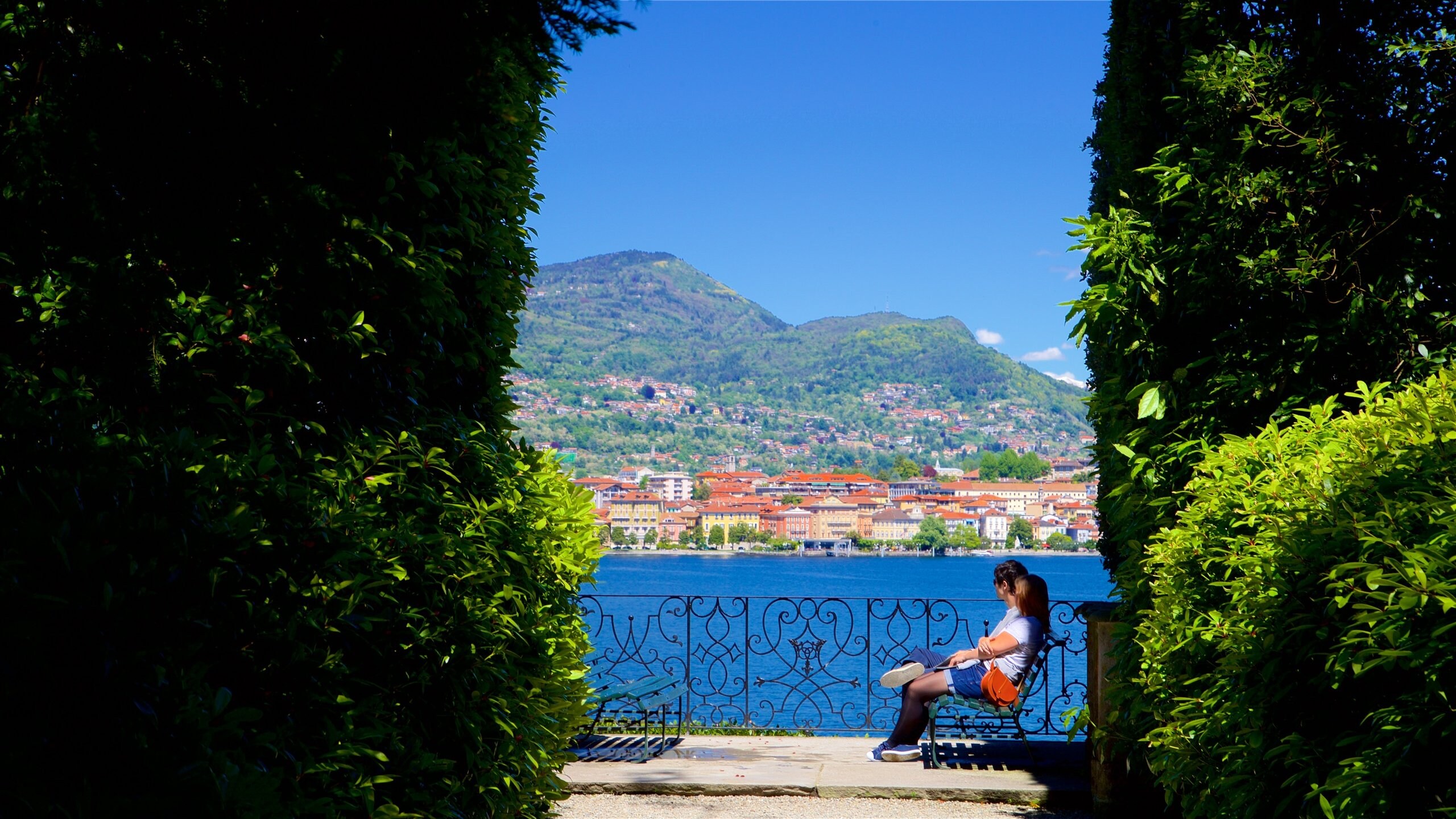 Isola Madre Botanical Garden which includes a small town or village, mountains and a lake or waterhole