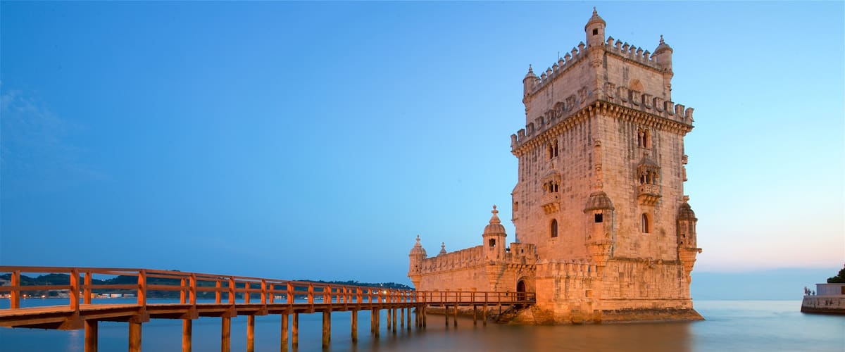 Belem Tower featuring a bridge, a sunset and heritage architecture